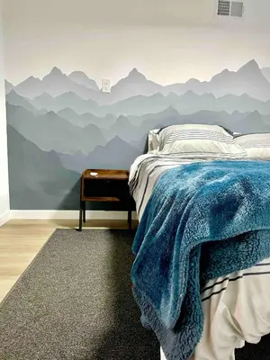 a bedroom with a mountain mural on the wall at Updated Mountain Cabin Retreat with 180 views off Deck and Balcony in Running Springs