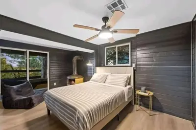 a bedroom with a bed and a ceiling fan at Updated Mountain Cabin Retreat with 180 views off Deck and Balcony in Running Springs