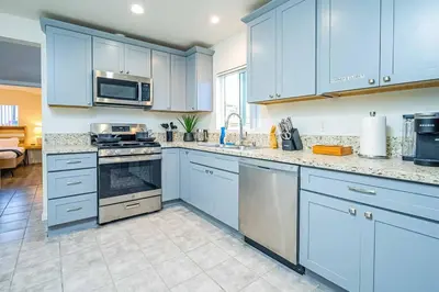 a kitchen with blue cabinets and a stove top oven at Stylish 2B2B country style house in Glendora
