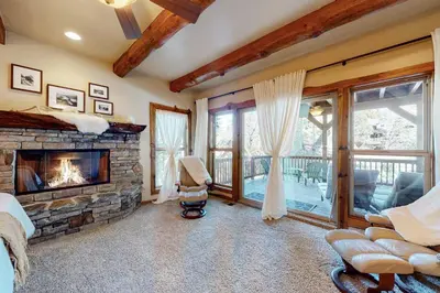 a living room with a stone fireplace and a couch at Arrowhead Haven in Lake Arrowhead