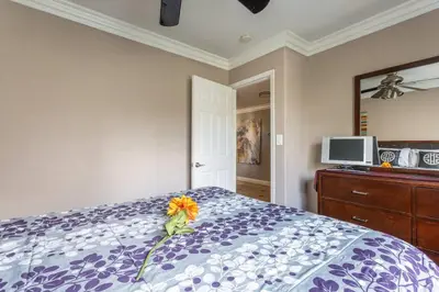 a bedroom with a bed with a flower on it at Amazing BBQ POOl home at center of LA\u7f8e\u5f0f\u56db\u623f\u5927\u5730\u6cf3\u6c60\u70e7\u70e4\u533a\u7f8e\u5c4b in Chino Hills