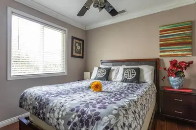 a bedroom with a bed with flowers on it at Amazing BBQ POOl home at center of LA\u7f8e\u5f0f\u56db\u623f\u5927\u5730\u6cf3\u6c60\u70e7\u70e4\u533a\u7f8e\u5c4b in Chino Hills