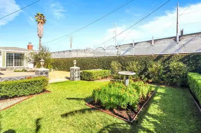a garden with plants and a bridge in the background at Luxury Home - 7mins LAX/Beach, 405/SoFi nearby in Hawthorne