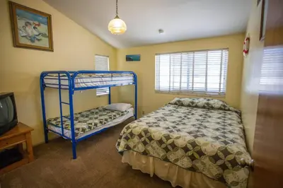 a bedroom with a bunk bed and a tv at Beautiful Ocean Front Coastal Sunset Beach House in Oxnard