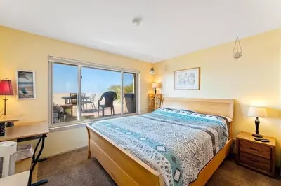 a bedroom with a bed and a desk and a window at Beautiful Ocean Front Coastal Sunset Beach House in Oxnard