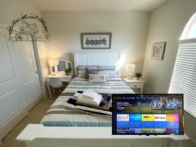 a bedroom with a bed with a laptop on a table at Bella's sweet house 11155 in Mira Loma