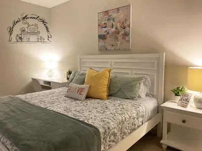 a bedroom with a bed with two night stands and two tables at Bella's sweet house 11155 in Mira Loma