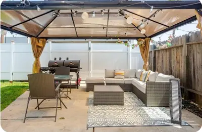 a pergola with a couch and a table and chairs at The Heart Of LA House in Los Angeles