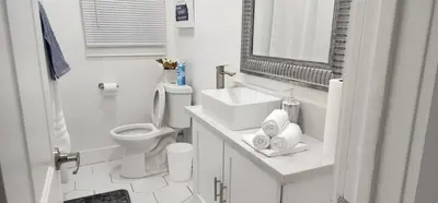 a white bathroom with a sink and a toilet at The Heart Of LA House in Los Angeles