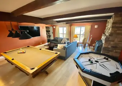 a living room with a pool table and a couch at Modern 6 bedroom retreat, stunning lake views, close to village! in Lake Arrowhead