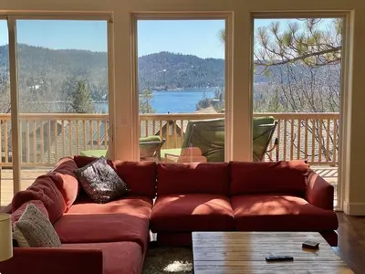 a living room with a couch in front of windows at Modern 6 bedroom retreat, stunning lake views, close to village! in Lake Arrowhead