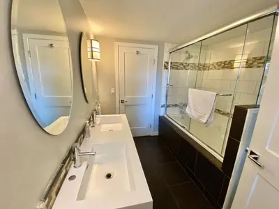 a bathroom with a sink and a mirror and a shower at Modern 6 bedroom retreat, stunning lake views, close to village! in Lake Arrowhead