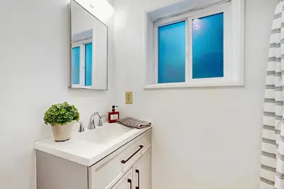 a bathroom with a sink and a mirror at Vintage Village Walk Cottage in Lake Arrowhead