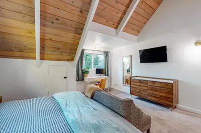 a bedroom with a bed and a tv on the wall at Saint Bernard Beauty in Lake Arrowhead