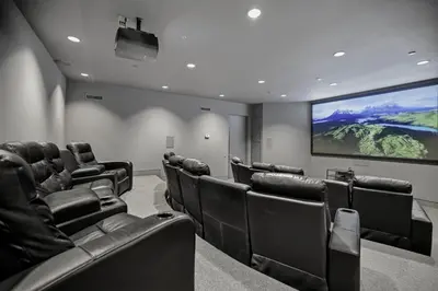 a cinema room with black chairs and a large screen at Winding Way in Malibu