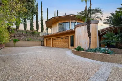 a house with a garage and a palm tree at Via Vallarta in Los Angeles