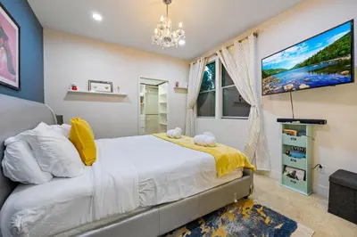 a bedroom with a large bed and a chandelier at Chic Silver Lake Oasis with Breathtaking City Skyline Views, Private Rooftop & Garage in Los Angeles