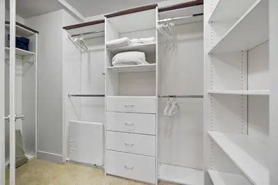 a white walk in closet with white shelves at Chic Silver Lake Oasis with Breathtaking City Skyline Views, Private Rooftop & Garage in Los Angeles