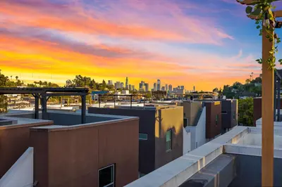 a view of the city at sunset from the roof of a building at Chic Silver Lake Oasis with Breathtaking City Skyline Views, Private Rooftop & Garage in Los Angeles