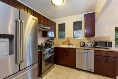 a kitchen with wooden cabinets and stainless steel appliances at Renovated Spanish 3BD 2BA near Beverly Hills in Los Angeles