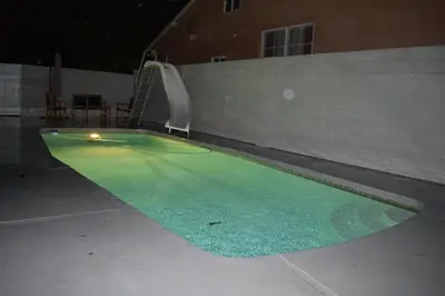 a swimming pool with green water in front of a building at Charming private guest Suite near Disney/Beach in Westminster