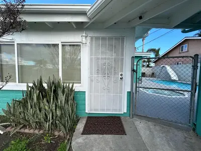 a house with a white door and a gate at Charming private guest Suite near Disney/Beach in Westminster