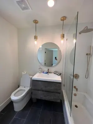 a bathroom with a toilet and a sink and a mirror at Gorgeous Private and Gated Home in Silver Lake with Pool & Views in Los Angeles