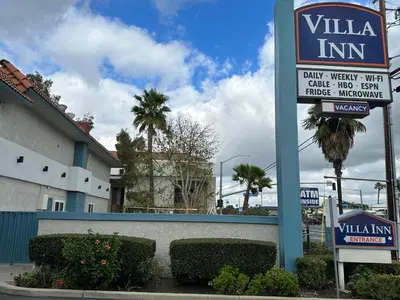 a sign for a villa inn next to a building at Villa Inn Anaheim in Anaheim