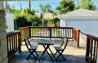 a wooden deck with two chairs and a table at Los Angeles Home Located in Beautiful Pasadena in Pasadena