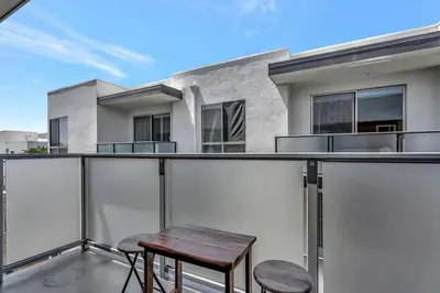 a balcony with a wooden table and two stools at 5 Heart of Santa Monica apartment in Los Angeles