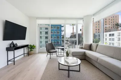 a living room with a couch and a flat screen tv at Level Long Beach - East Village in Long Beach