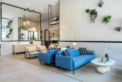 a lobby with blue couches and chairs and a table at Level Long Beach - East Village in Long Beach