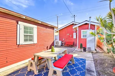 a wooden table and a bench in front of a red building at 7 Mi to Downtown Long Beach Bungalow with Patio! in Long Beach