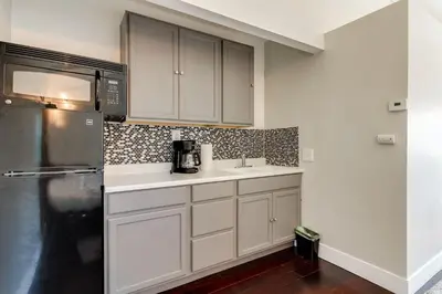 a kitchen with white cabinets and a black refrigerator at San Fernando Pool home + Large Private Guest House in San Fernando