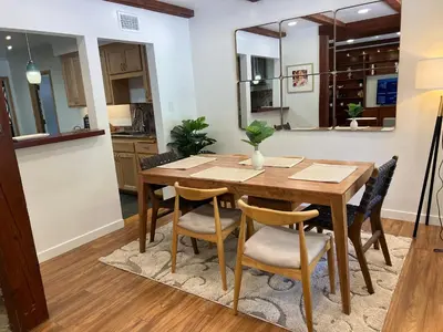 a dining room with a wooden table and chairs at Villa La Reforma - Newly Designed 4BR HOUSE & POOL in Los Angeles by Topanga in Los Angeles