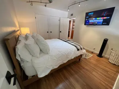 a bedroom with a bed with a television on the wall at Villa La Reforma - Newly Designed 4BR HOUSE & POOL in Los Angeles by Topanga in Los Angeles