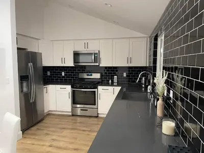 a kitchen with white cabinets and stainless steel appliances at Gated private house with own parking Sherman Oaks in Los Angeles