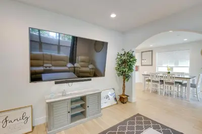 a living room with a large television on the wall at Pet-Friendly Paramount Home, 16 Mi to Los Angeles! in Paramount