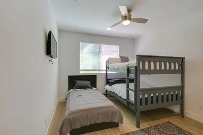 a bedroom with two bunk beds and a fan at Pet-Friendly Paramount Home, 16 Mi to Los Angeles! in Paramount