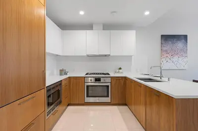 a kitchen with wooden cabinets and a stove top oven at Level Downtown LA South Olive in Los Angeles