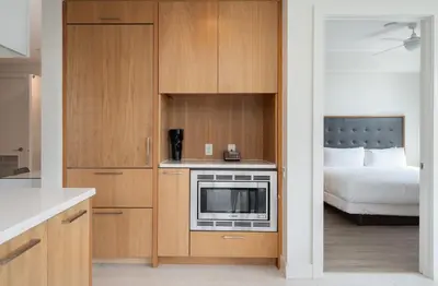 a kitchen with a microwave and a bed in a room at Level Downtown LA South Olive in Los Angeles