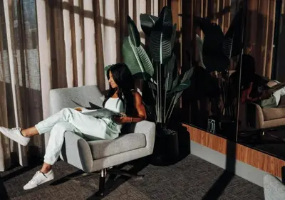 a woman sitting in a chair reading a book at Level Downtown LA South Olive in Los Angeles