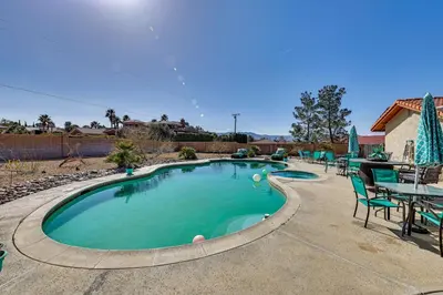 a swimming pool with a table and chairs at Spacious Apple Valley Home with Pool and Yard! in Apple Valley