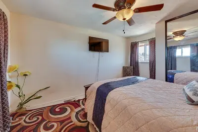 a bedroom with a bed and a ceiling fan at Spacious Apple Valley Home with Pool and Yard! in Apple Valley