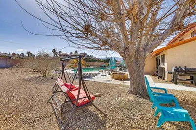 a swing in a yard next to a tree at Spacious Apple Valley Home with Pool and Yard! in Apple Valley