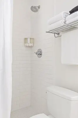 a white bathroom with a toilet and a shower at The Varden - A Self-Service Micro Hotel in Long Beach