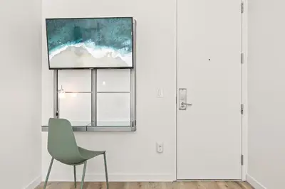 a chair in a room with a painting on the wall at The Varden - A Self-Service Micro Hotel in Long Beach