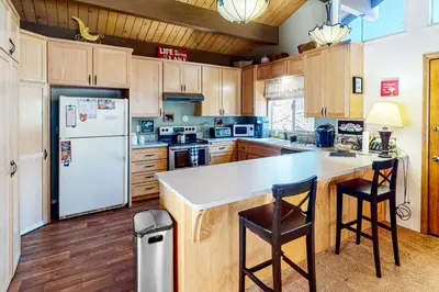 a kitchen with a white refrigerator and wooden cabinets at Edelwiess Wonder in Crestline
