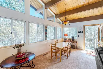 a dining room with a table and some windows at Edelwiess Wonder in Crestline