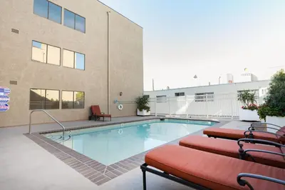 a swimming pool with two chairs next to a building at N Hollywood 2BR w Gym Pool nr TJ Shops LAX-591 in Los Angeles